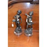 A pair of early 20th Century French bronzed putti on marble stands, signed to base Rousseau