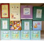 A collection of twelve Winnie the Pooh figurines in boxes including Doulton and Disney