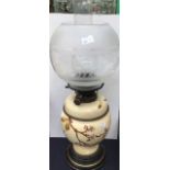 An early 20th Century ceramic and glass oil lamp with funnel and shade oil section (AF) peach tree