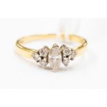 An 18ct gold and diamond ring, comprising a central marquise diamond,  with brilliant cut diamond
