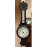An early 20th Century ebonised oak banjo barometer and thermometer, with scroll carved decoration