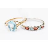 A 9ct white gold blue topaz and garnet set ring, comprising marquise and round cut stones, size