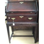 A mid 18th Century oak bureau on stand, having a fall front over a single drawer, raised on square