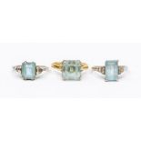 A collection of three aquamarine rings, to include a square cut claw set ring in 18ct yellow gold,