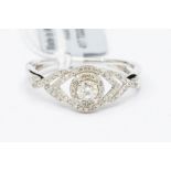 A diamond and 9ct white gold dress ring, set to the centre with a claw set brilliant cut diamond,