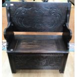 An early 20th Century oak monks bench, the back folding down and forming a table, 98cm high, 92cm