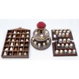 Collection of Derby and Minton thimbles on stands and pin cushion stand.