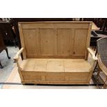 A late 19th Century/early 20th Century ash and pine box settle, four panels to back, hinged seat