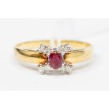 A ruby and diamond 18ct gold cluster ring, the central oval ruby approx. 4mm x 3mm, claw set