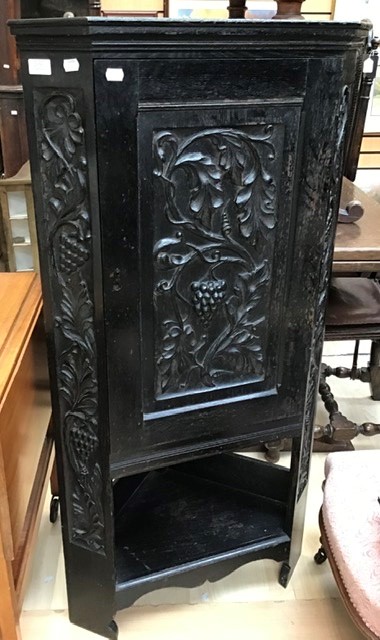 A Victorian oak floor standing corner cabinet, hand carved door and ebonised single door, originally