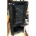 A Victorian oak floor standing corner cabinet, hand carved door and ebonised single door, originally