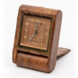 A Jaeger-LeCoultre snakeskin cased travel alarm clock, with eight day movement in tan folding