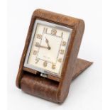 A Jaeger-LeCoultre snake skin cased travel clock, with eight day movement in tan folding case,