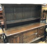 A 1920s oak sideboard, two doors and two drawers, rack above with adjustable shelf