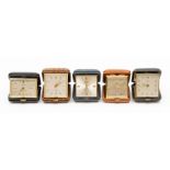 Five small leather cased travel clocks, the Swiss eight day movements in square cases, varying