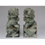 A pair of Chinese carved jade Dogs of Foe, each seated on a carved block plinth base, 20th