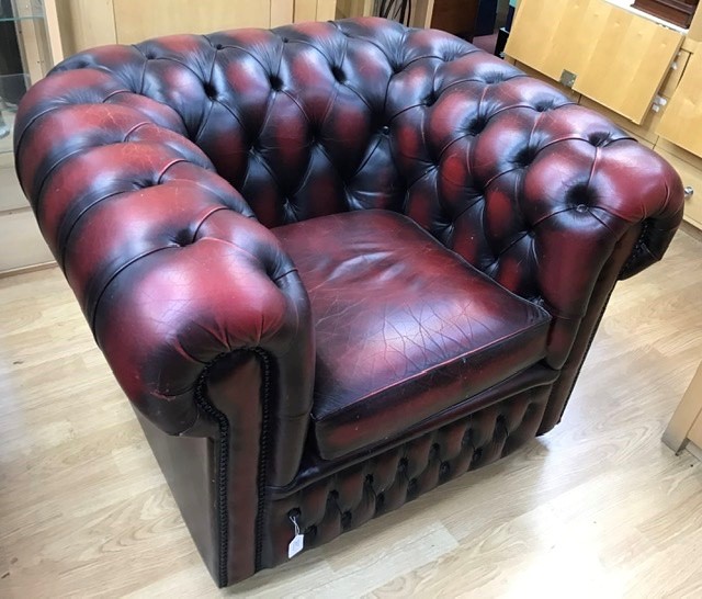 A pair of Chesterfield type oxblood leather upholstered club armchairs, with deep buttoned backs and