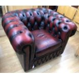 A pair of Chesterfield type oxblood leather upholstered club armchairs, with deep buttoned backs and