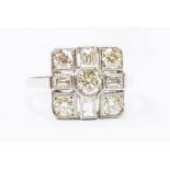 A diamond and platinum dress ring, the cushion shaped mount set to the centre with a round brilliant