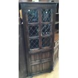 A traditional oak lead glazed bookcase and a matching free standing corner unit; the glazed bookcase