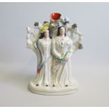 A Staffordshire Portrait  figure of Two Ladies  standing before a Spill holder with branches, with a