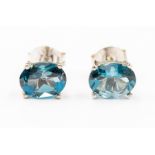 A pair of blue topaz and silver stud earrings, the oval London blue topaz approx. 8.2 x 6.3mm,