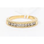 A diamond and 18ct gold channel set half eternity ring, the top set with nine brilliant cut