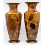 Two Royal Doulton stone ware vases, each decorated with hand painted leaves on an autumnal ground,
