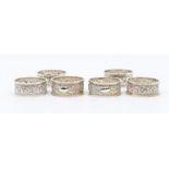 A set of six late Victorian silver floral and scrolled embossed napkin rings, by Henry Wilkinson,