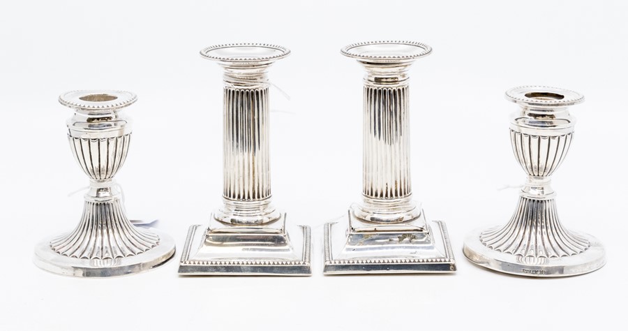 A pair of Edwardian silver corinthian column candlesticks with plain capitals, detachable drip pans,