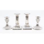 A pair of Edwardian silver corinthian column candlesticks with plain capitals, detachable drip pans,
