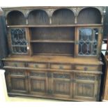 A traditional oak glazed dresser, the upper section with a shelved section, two glazed doors, the