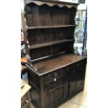 A 20th Century oak dresser with plate rack, the rack with two shelves, the base section with two