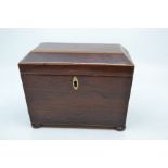 A 19th Century mahogany inlaid tea caddy, of sarcophagus form on four cushion feet, the interior