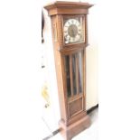 An early 20th Century oak Grandmother clock, the face with a silvered chapter dial and black Roman