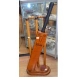 A set of cricket stumps with signed bat and ball on a display stand, signed by West Indies and