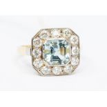 An aquamarine and diamond 18ct gold dress ring, octagonal mounts set to the centre with a rub-over