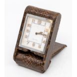 A Jaeger-LeCoultre snakeskin cased travel clock, with eight day movement in dark brown folding case,