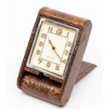 A Jaeger-LeCoultre snakeskin cased travel clock, with eight day movement in dark brown folding case,