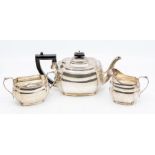 A George VI silver three piece tea service, the teapot with ebony pagoda finial and handle by George