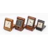 Four various travel alarm clocks, with eight day movements, two in tan crocodile folding cases,