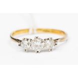 A diamond and 18ct gold three stone ring, the double claw set round brilliant cut diamonds with a