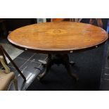 A late Victorian mahogany oval breakfast table, the tilting top raised on a pedestal base, raised on