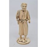 A Japanese sectional ivory figure of a farmer, Meiji period, modelled standing on a circular base,