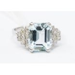 An aquamarine and diamond platinum dress ring, the claw set emerald cut aqua weighting approx.