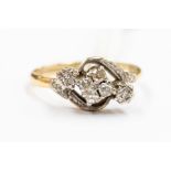 A diamond and 18ct gold dress ring, comprising a central quatrefoil diamond cluster, two illusion