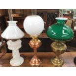 A collection of nine early to mid 20th Century oil lamps with shades and funnels