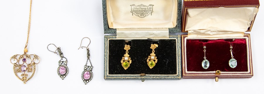 A pair of peridot and peal set earrings, fancy scrolled mounts, unmarked  assessed as 15ct gold,