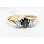 An 18ct gold and sapphire diamond three stone ring, oval sapphire claw set to the centre, weight