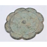 A Chinese bronze mirror of lobed circular form and cast with phoenix birds in flight around a